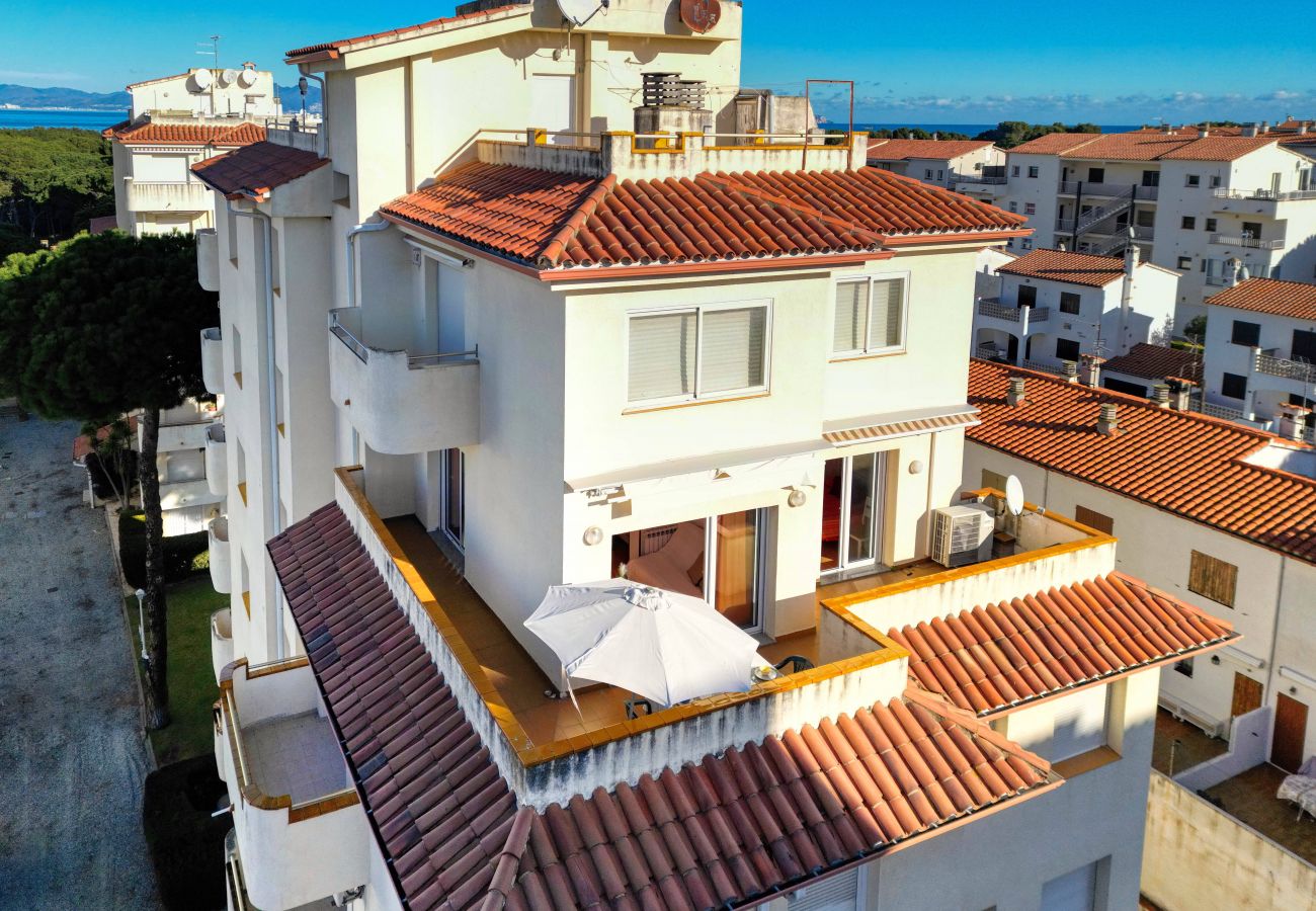 Luftaufnahme der Terrasse, die die schöne Wohnung mit Gemeinschaftspool in L'Escala umgibt