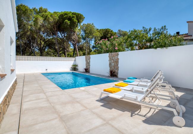 Sun loungers and swimming pool of a magnificent house for rent in l'Escala