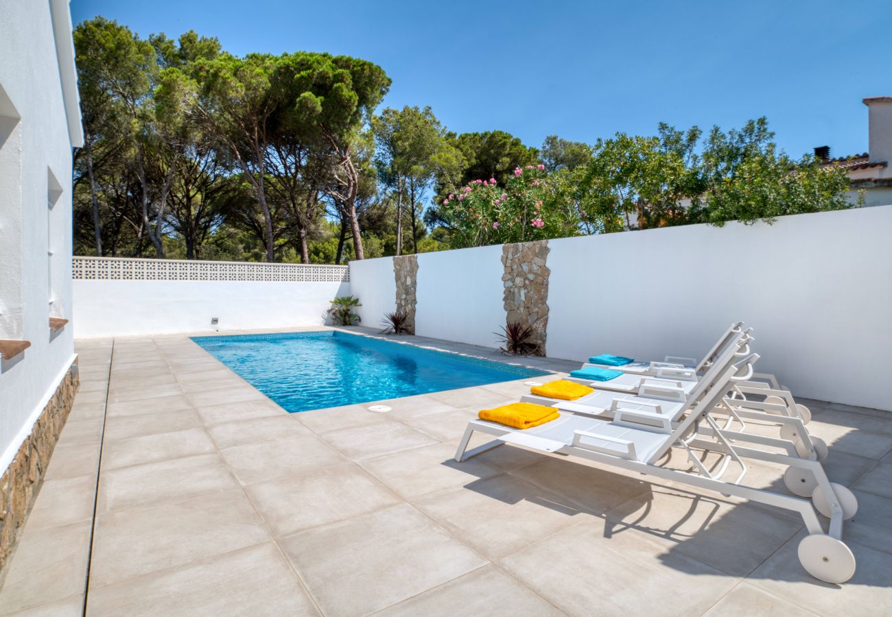 Sun loungers and swimming pool of a magnificent house for rent in l'Escala