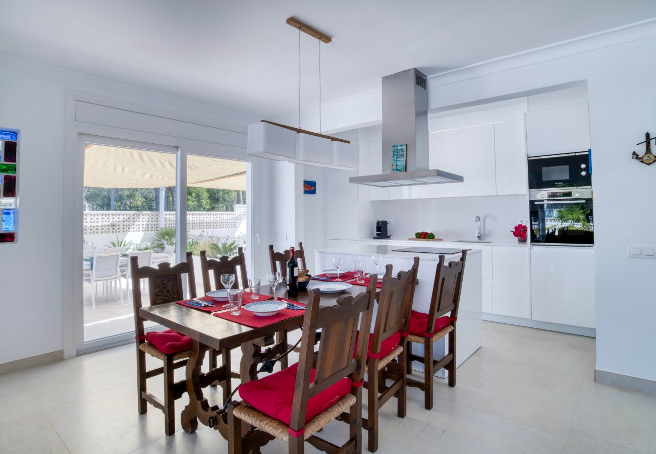 Salle à manger lumineuse avec cuisine ouverte.