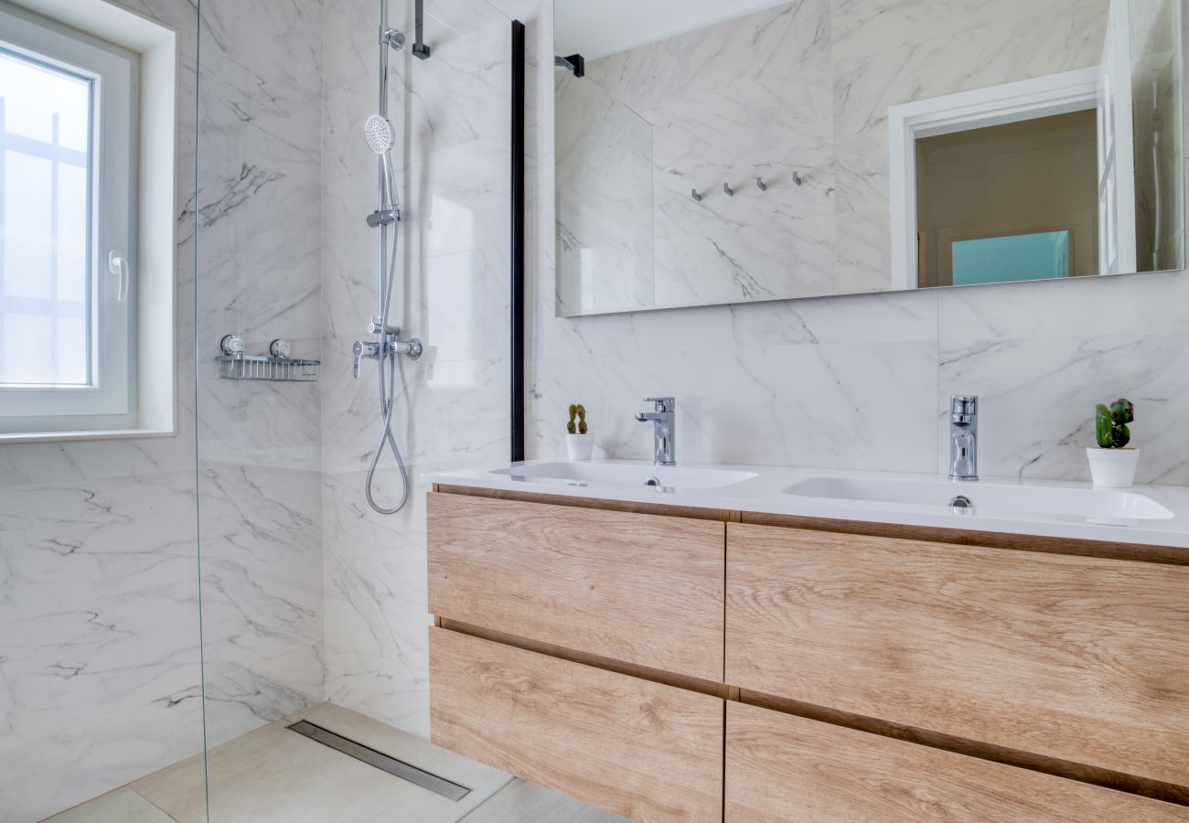 Salle de bain lumineuse avec douche à l’italienne.