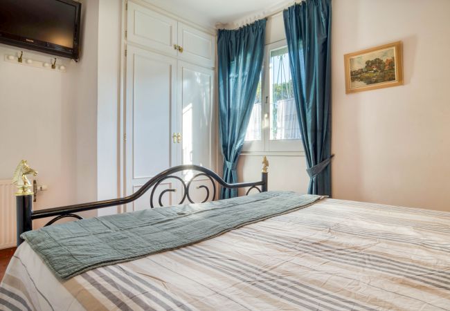 Chambre à coucher avec armoire intégrée et rideaux bleus d'une maison à l'Escala