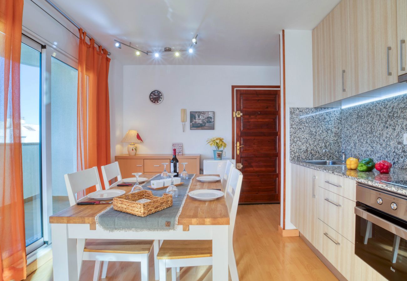 Appartement à louer à l'Escala avec une salle à manger avec une table et quatre chaises blanches en bois
